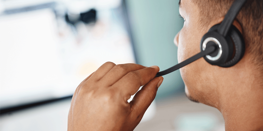 Man on his headset looking at his computer.